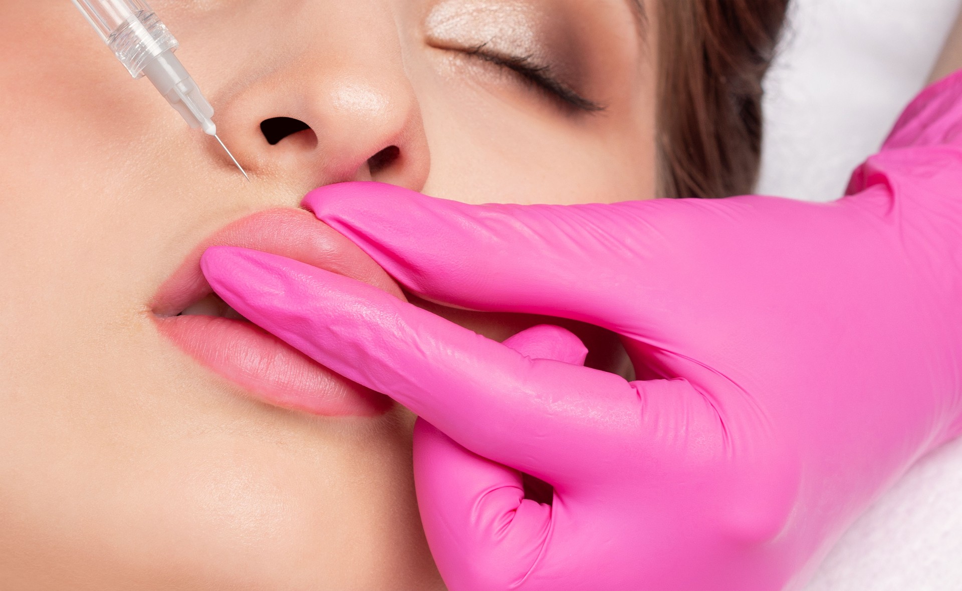 Cosmetologist does injections for lips augmentation and anti wrinkle in the nasolabial folds of a beautiful woman. Women's cosmetology in the beauty salon.